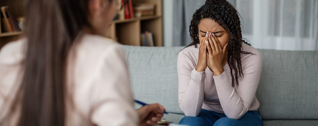 psychologist leading a therapy session and taking notes during counselling