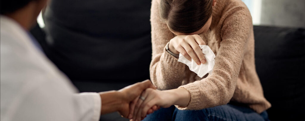 psychologist leading a therapy session and taking notes during counselling